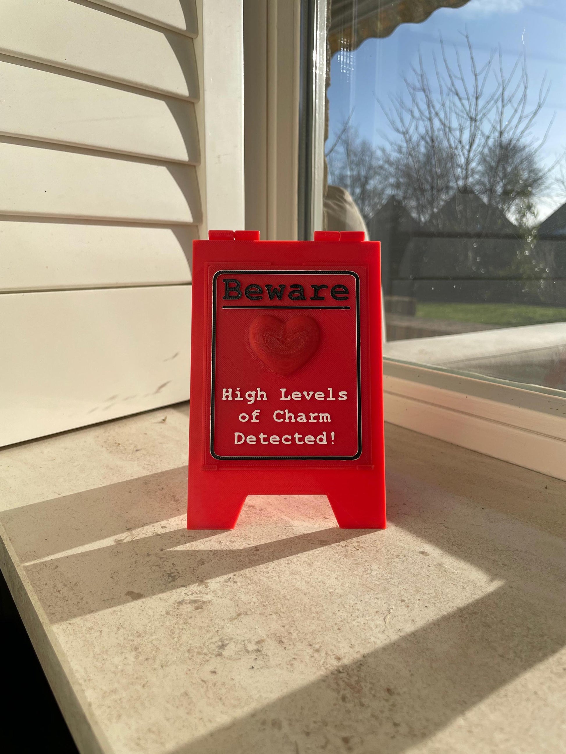 Funny Desk Sign Red A Frame – “Beware High Levels of Charm” Perfect Quirky Gift & Cute Novelty Tabletop Decor!