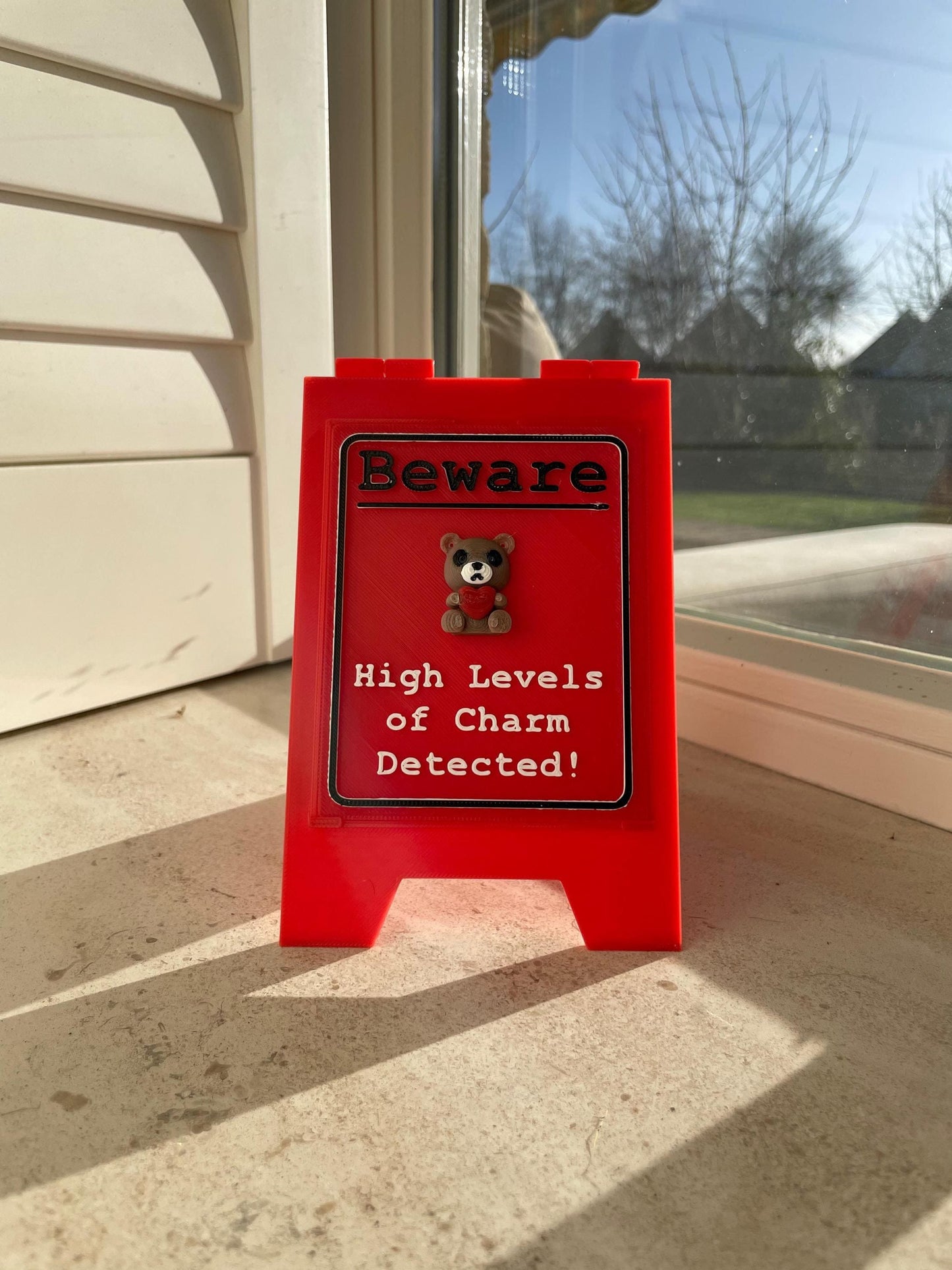 Funny Desk Sign Red A Frame – “Beware High Levels of Charm” Perfect Quirky Gift & Cute Novelty Tabletop Decor!